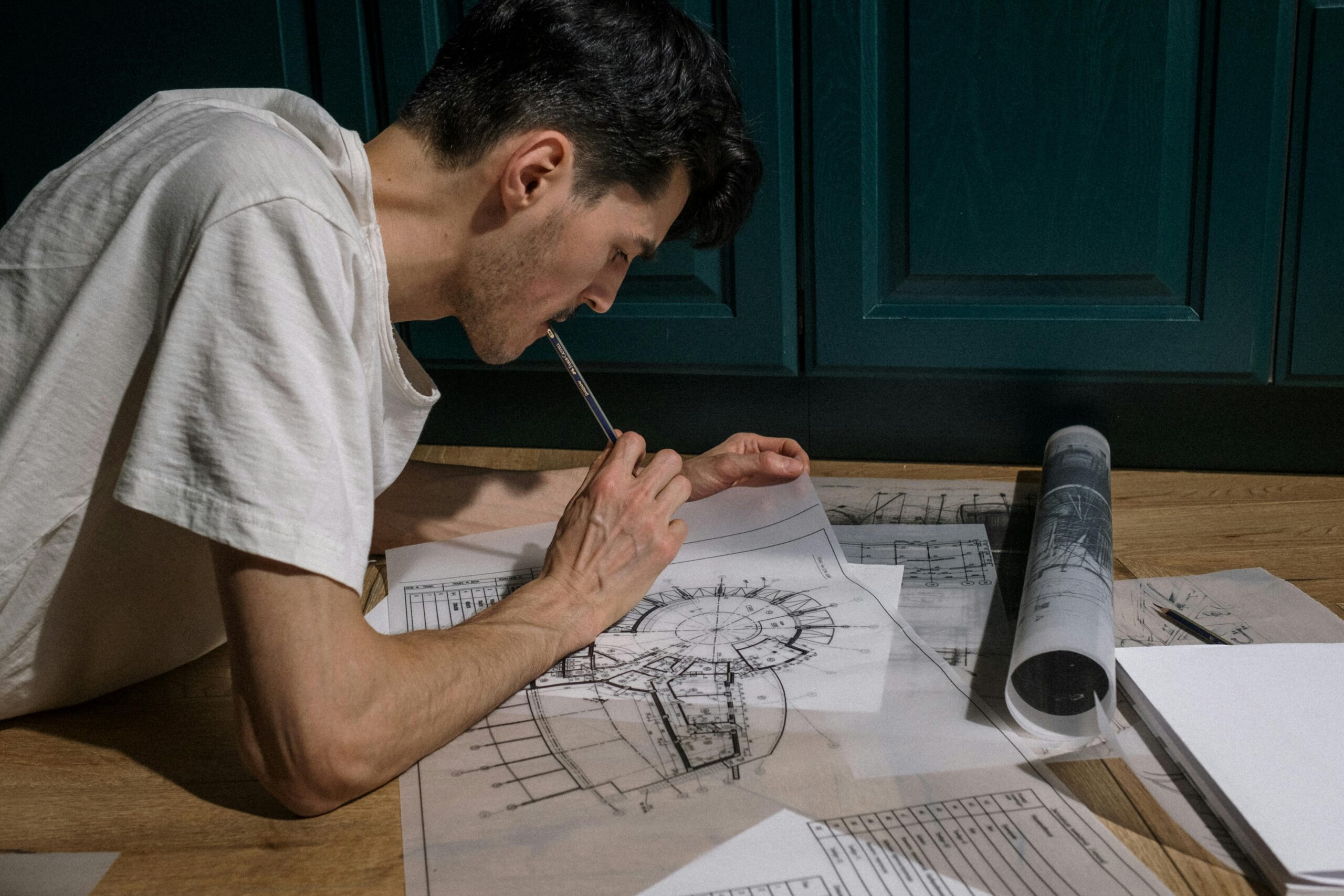 Focused architect drawing floor plans indoors on a tablet for a design project.